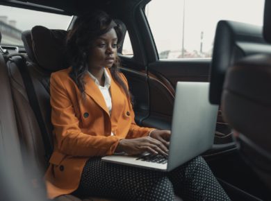 woman wearing a blazer sitting inside the car